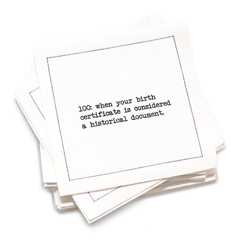 Organic cotton cocktail napkin with black dotted border printed with the quote "100: when your birth certificate is considered a historical document," from Five Star Napkins' 100th birthday quote collection