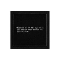 Black 30th birthday quote cocktail napkin with white typewriter-style text reading, “Welcome to 30! The age when you should know better, but really don’t.”