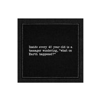 Organic cotton cocktail napkin, black, with white dotted border printed with the quote "Inside every 40 year old is a teenager wondering, 'what on Earth happened?'" from Five Star Napkins' 40th Birthday Quotes collection