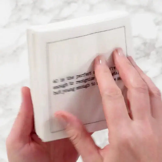 Video close-up of hands touching an organic cotton cocktail napkin printed with a 40th birthday quote, from Five Star Napkins' 40th Birthday Quotes collection
