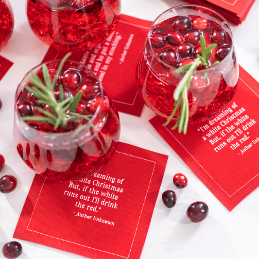 Persimmon organic cotton napkins with Christmas quote, red cocktails and cranberries on table