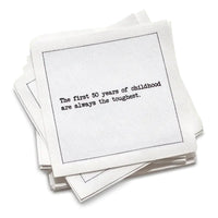 Organic cotton cocktail napkin with black dotted border printed with the quote "The first 50 years of childhood are always the toughest," from Five Star Napkins' 50th birthday quote collection