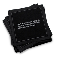 Organic cotton cocktail napkin, black, with white dotted border printed with the quote "Don't worry about being 50. You are still going to make mistakes, only slower," from Five Star Napkins' 50th birthday quote collection