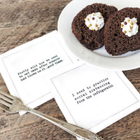 White organic cotton napkins with printed quotes, chocolate dessert and fork on rustic table