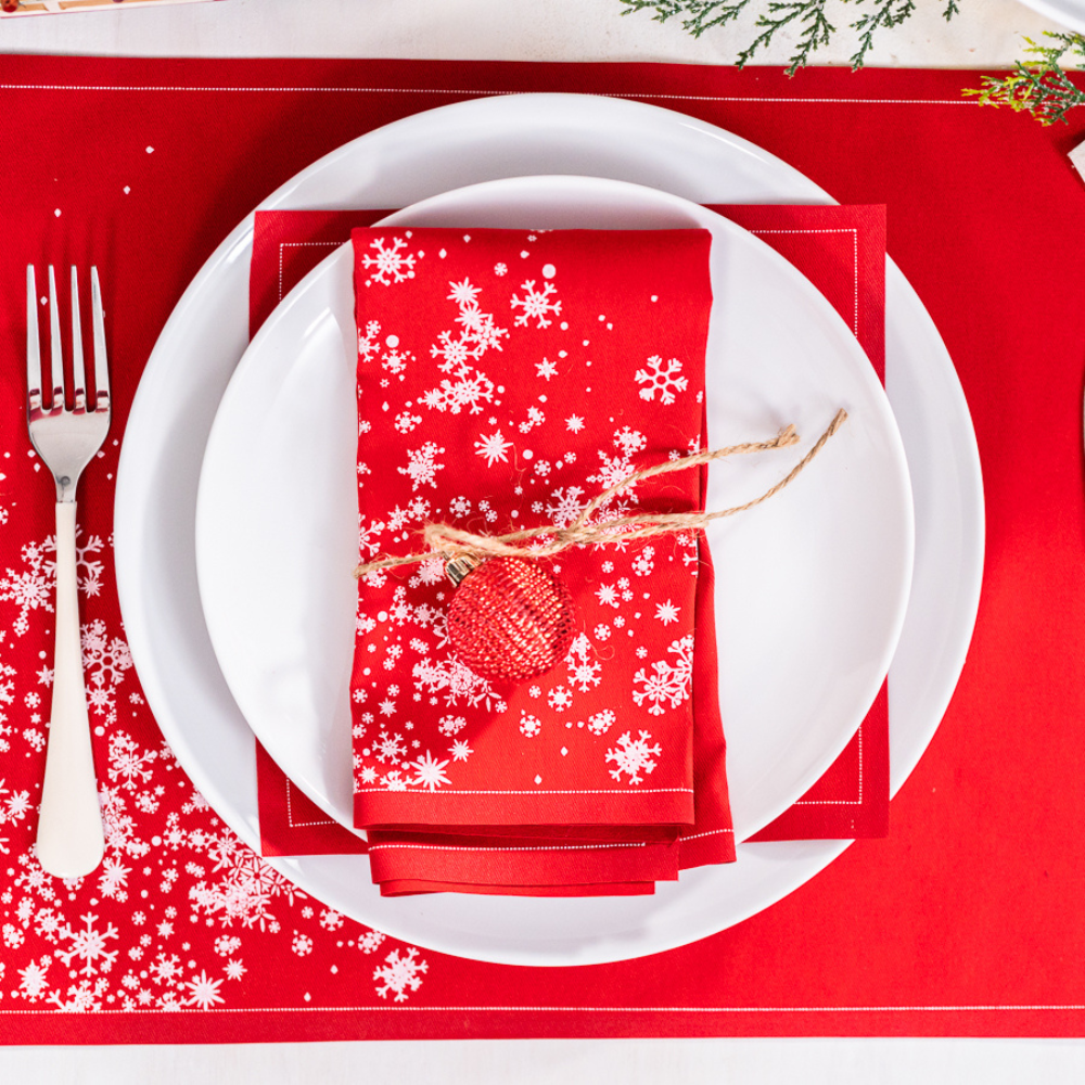 Organic cotton Persimmon napkin with white snowflake pattern on formal holiday place setting