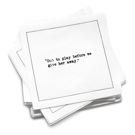 Stack of white organic cotton cocktail napkins with black dotted border printed with the quote “Out to play before we give her away,” from Five Star Napkins' Bachelorette quote collection
