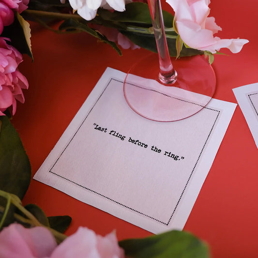 Organic cotton cocktail napkin with 'Last fling before the ring.' quote, floral table setting