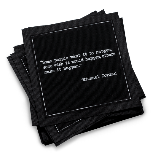 Black organic cotton cocktail napkins with a white inspirational quote from Michael Jordan.