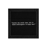 A single black Beer Quotes cocktail napkin printed with a white dotted border and the phrase, “Anyone can drink beer, but it takes intelligence to enjoy beer.”