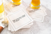 Glasses of beer rest on scattered white Beer Quotes cocktail napkins beside a bottle opener. The top napkin reads, “Today I was a hero. I rescued some beer that was trapped in a bottle.”