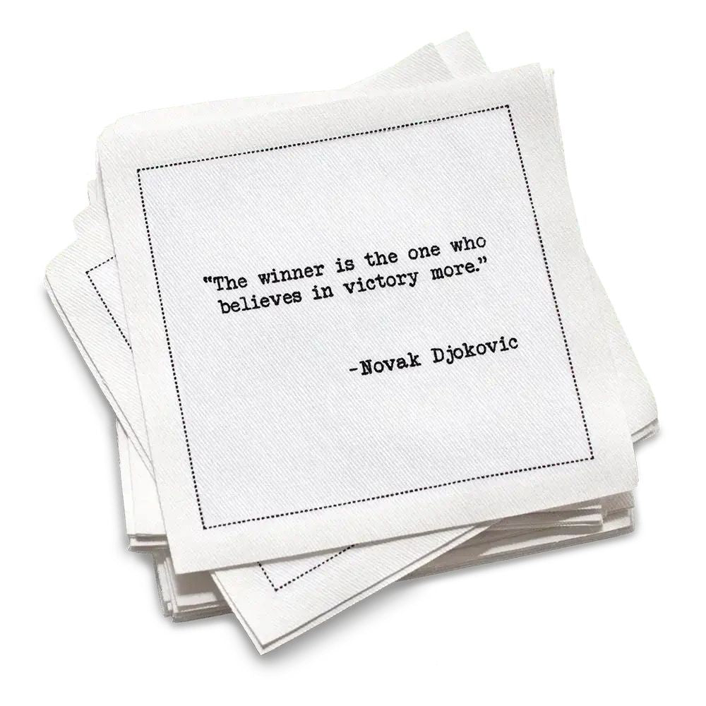 Stack of white cotton cocktail napkins with a black quote by Novak Djokovic on a white background