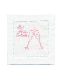 Organic cotton cocktail napkin with pink embroidery, featuring 'But First... Cocktails' quote and two glasses.