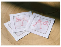Organic cotton cocktail napkins with pink embroidered quote and champagne glass illustration