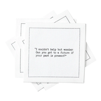 Stack of white organic cotton cocktail napkins with black dotted border printed with the quote “I couldn't help but wonder: Can you get to a future if your past is present?” from Five Star Napkins' Carrie Bradshaw quote collection