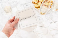 Hand holding organic cotton quote napkin printed with 'I'm only talking to my cat today' at cocktail party table.