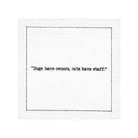 Organic cotton cocktail napkin with quote 'Dogs have owners, cats have staff.' in black text