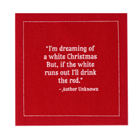 Close-up of a red organic cotton cocktail napkin printed with the quote, “I’m dreaming of a white Christmas. But, if the white runs out I’ll drink the red.” – Author Unknown.