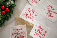 Holiday cocktail party scene with organic cotton napkins in white and red, featuring printed quotes like 'Let it Snow' and festive decor.