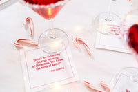 Organic cotton quote napkin with red text, Matt Groening Christmas quote, cocktail party setting with candy canes and drinks
