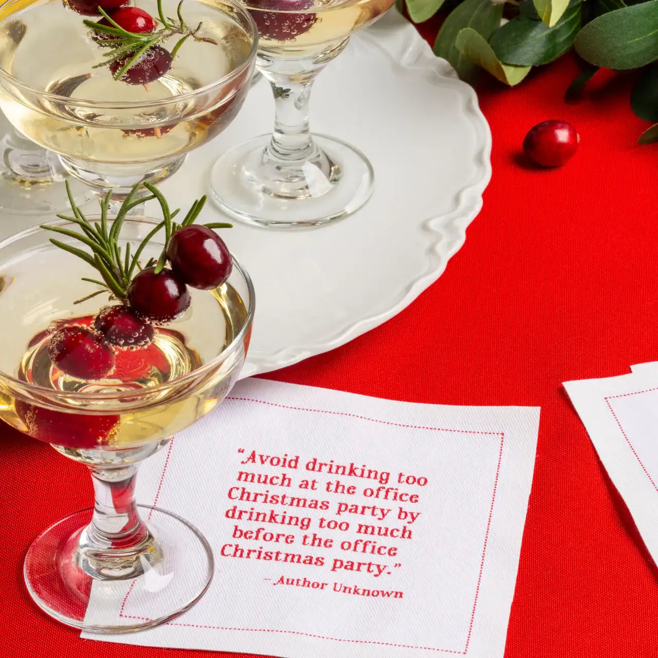 Organic cotton cocktail napkin in Toreador with printed quote, champagne glasses, holiday table setting