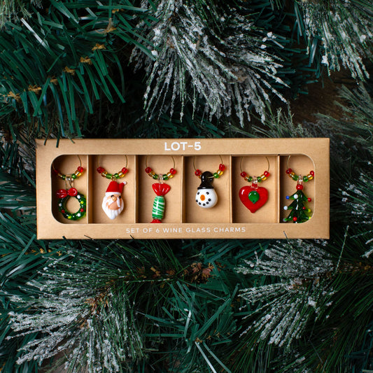 Set of 6 wine glass charms on a Christmas tree background