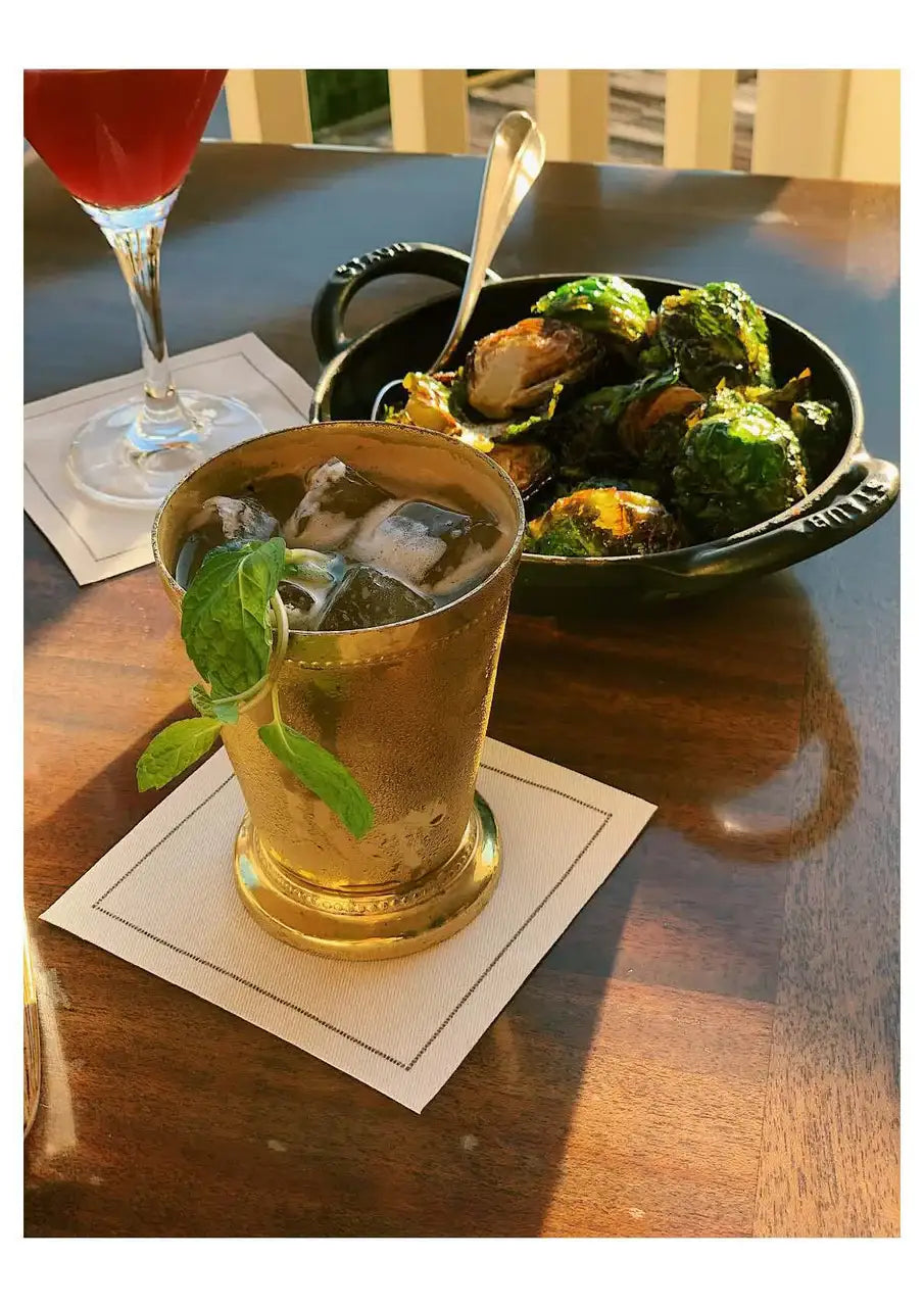 White organic cotton cocktail napkins under drinks at a table setting with food