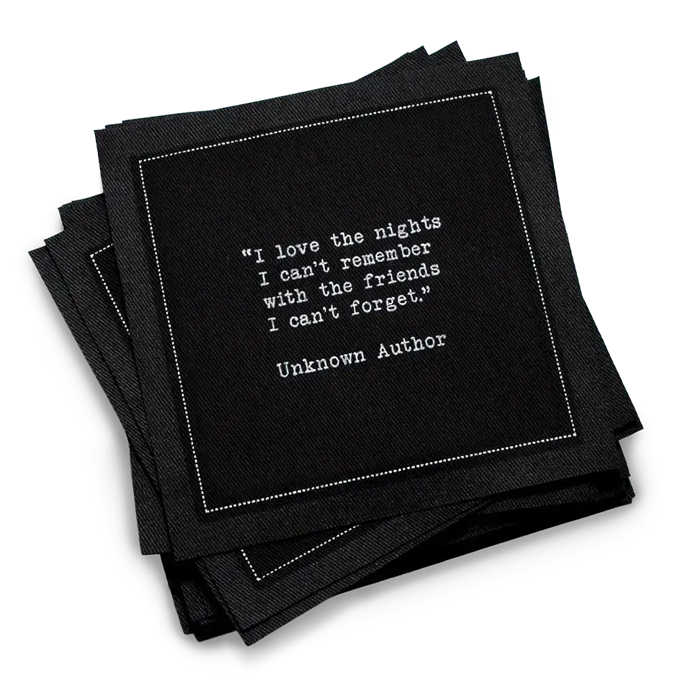 Stack of black drinking quote cocktail napkins with white typewriter-style text reading, “I love the nights I can’t remember with the friends I can’t forget.” – Unknown Author.