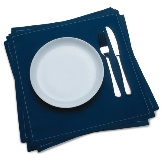 Midnight blue organic cotton dinner napkins with white plate, fork, and knife