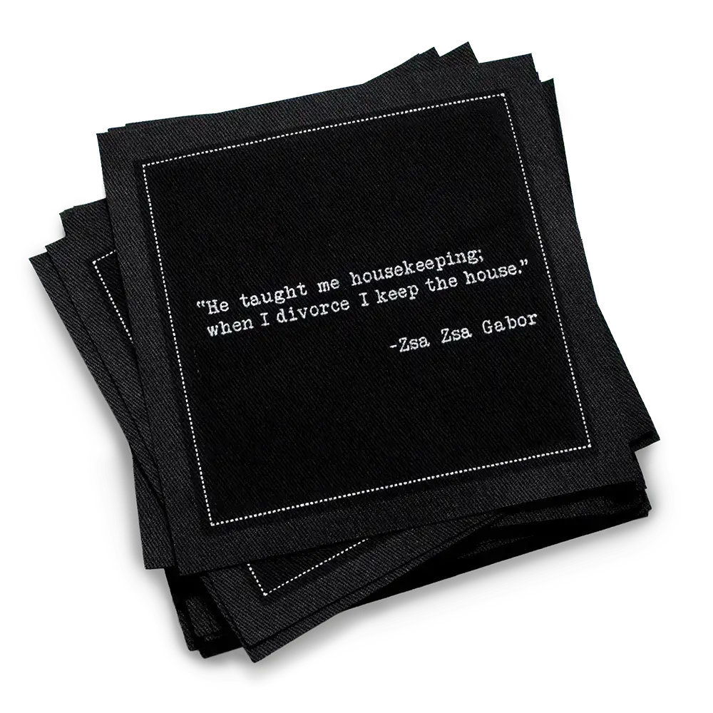Organic cotton cocktail napkin, black, with white dotted border printed with the Zsa Zsa Gabor quote "He taught me housekeeping; when I divorce I keep the house," from Five Star Napkins' Divorce quote collection