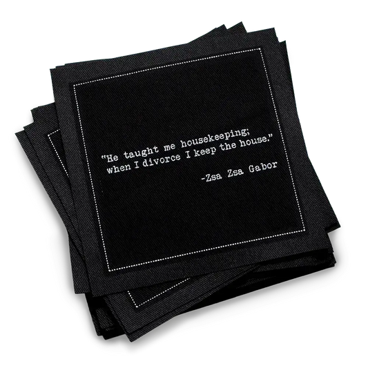 Organic cotton cocktail napkin, black, with white dotted border printed with the Zsa Zsa Gabor quote "He taught me housekeeping; when I divorce I keep the house," from Five Star Napkins' Divorce quote collection