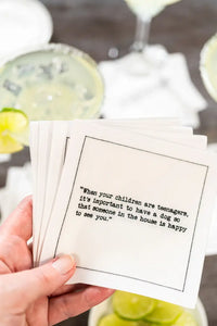 Organic cotton cocktail napkin with printed quote, hand holding at a cocktail party table setting