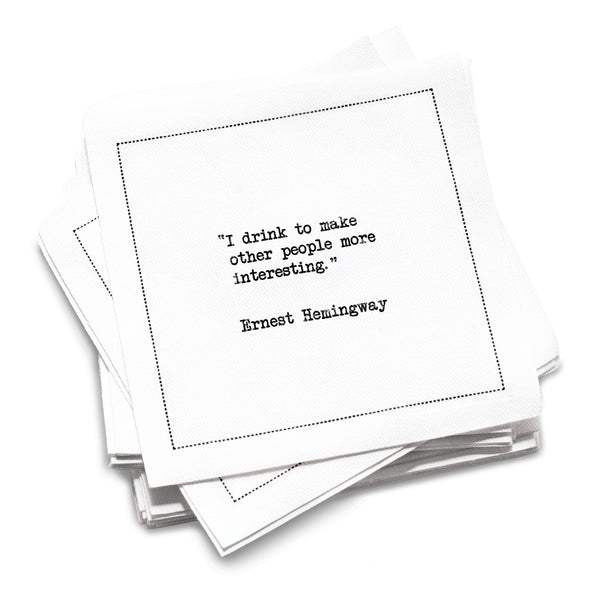 Funny white cotton cocktail napkin from The Drinking Quotes First Edition, printed with black typewriter-style text reading, “I drink to make other people more interesting.” – Ernest Hemingway.