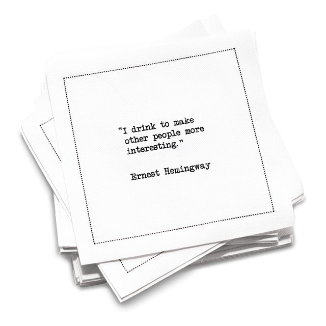 Funny white cotton cocktail napkin from The Drinking Quotes First Edition, printed with black typewriter-style text reading, “I drink to make other people more interesting.” – Ernest Hemingway.