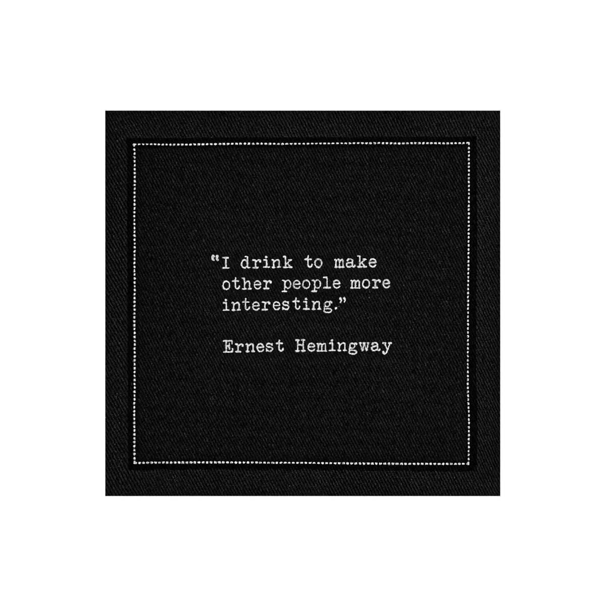 Black cocktail napkin from The Drinking Quotes First Edition, printed with white typewriter-style text reading, “I drink to make other people more interesting.” – Ernest Hemingway.