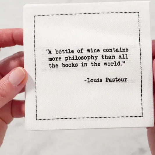 White cocktail napkin from The Drinking Quotes Second Edition, printed with black typewriter-style text reading, “A bottle of wine contains more philosophy than all the books in the world.” – Louis Pasteur.