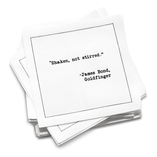 50 White Cotton Cocktail Napkins from The Drinking Quotes Second Edition, featuring quotes by famous actors and authors, in black typewriter-style text reading, “Shaken, not stirred.” – James Bond, Goldfinger.