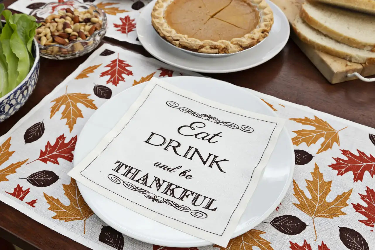 Organic cotton napkin with 'Eat Drink and be Thankful' quote on autumn leaf table setting