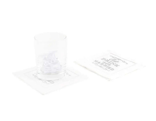 Organic cotton napkin with printed quote 'Eat Drink Be Married' under a glass, stack beside