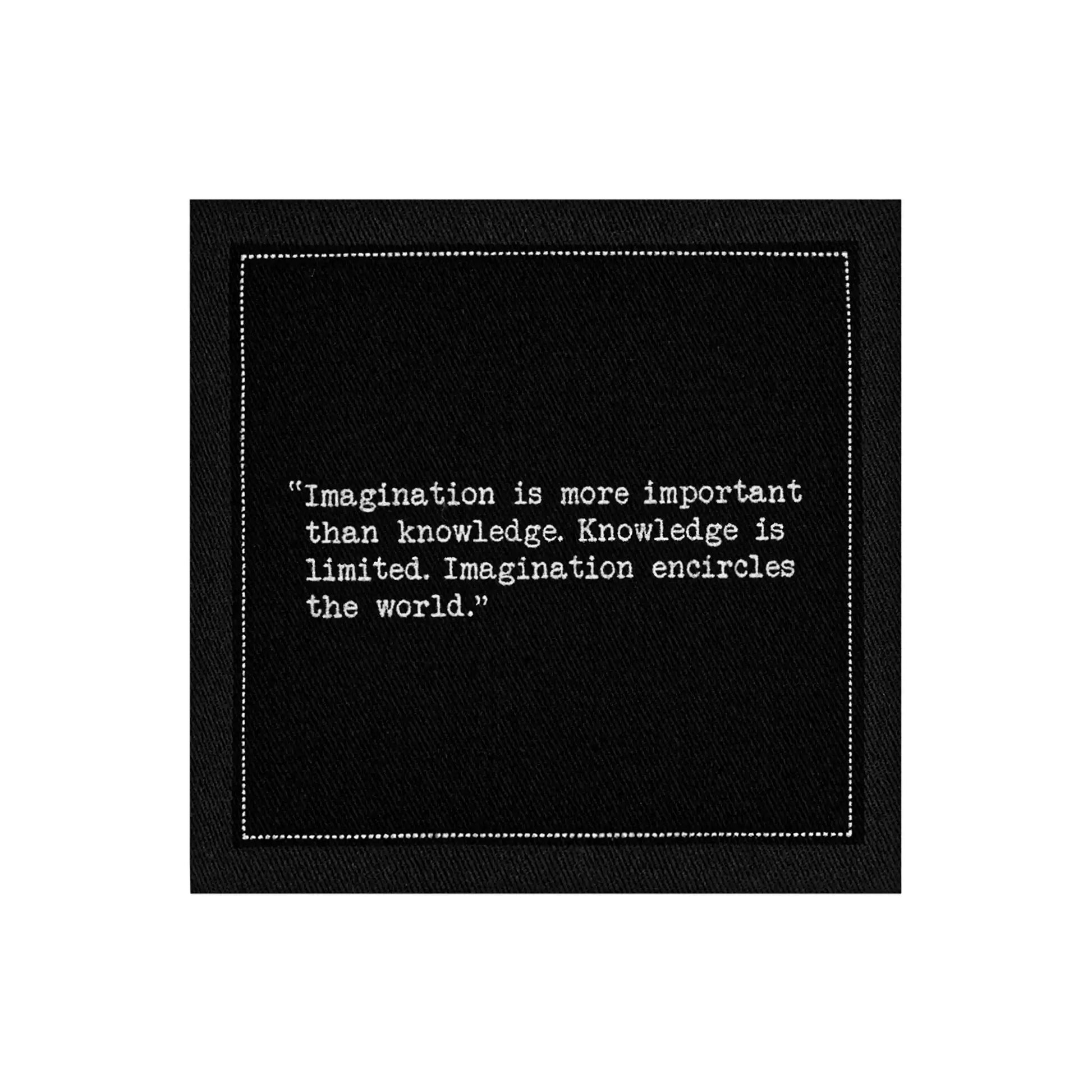 Organic cotton cocktail napkin, black, with white dotted border printed with the quote "Imagination is more important than knowledge. Knowledge is limited. Imagination encircles the world," from Five Star Napkins' Einstein quote collection