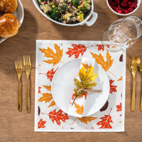 Autumn leaf print organic cotton napkin and placemat on dining table with gold flatware