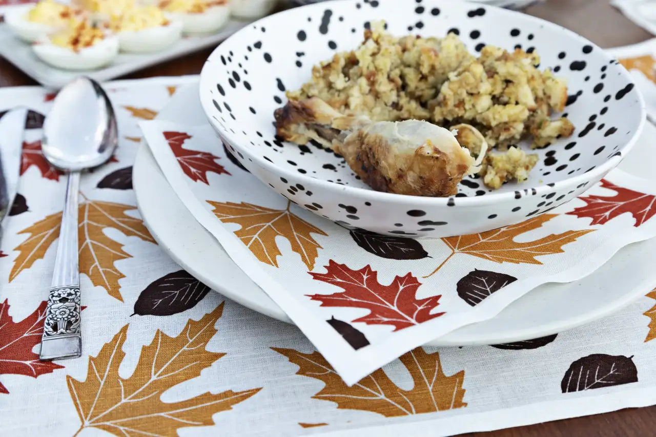 Organic cotton napkin with Persimmon, Anthracite Grey, and golden leaf print at a fall place setting