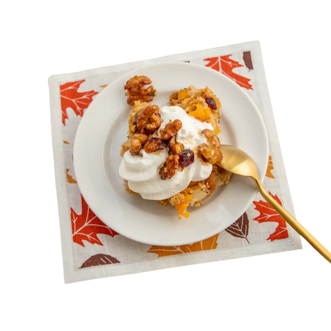 Dessert on a white plate atop a fall-themed luxury cotton cocktail napkin with gold spoon