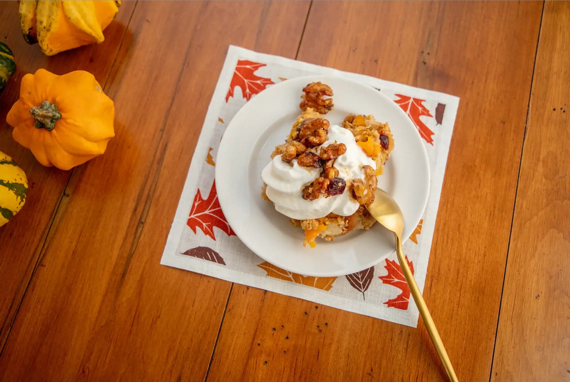 Fall-themed organic cotton napkin with dessert and gourds on wooden table