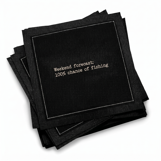 Organic cotton cocktail napkin, black, with white dotted border printed with the quote "Weekend forecast: 100% chance of fishing," from Five Star Napkins' Fishing Quote collection