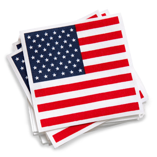 A stack of white cocktail napkins printed with a bold red, white, and blue American flag design.