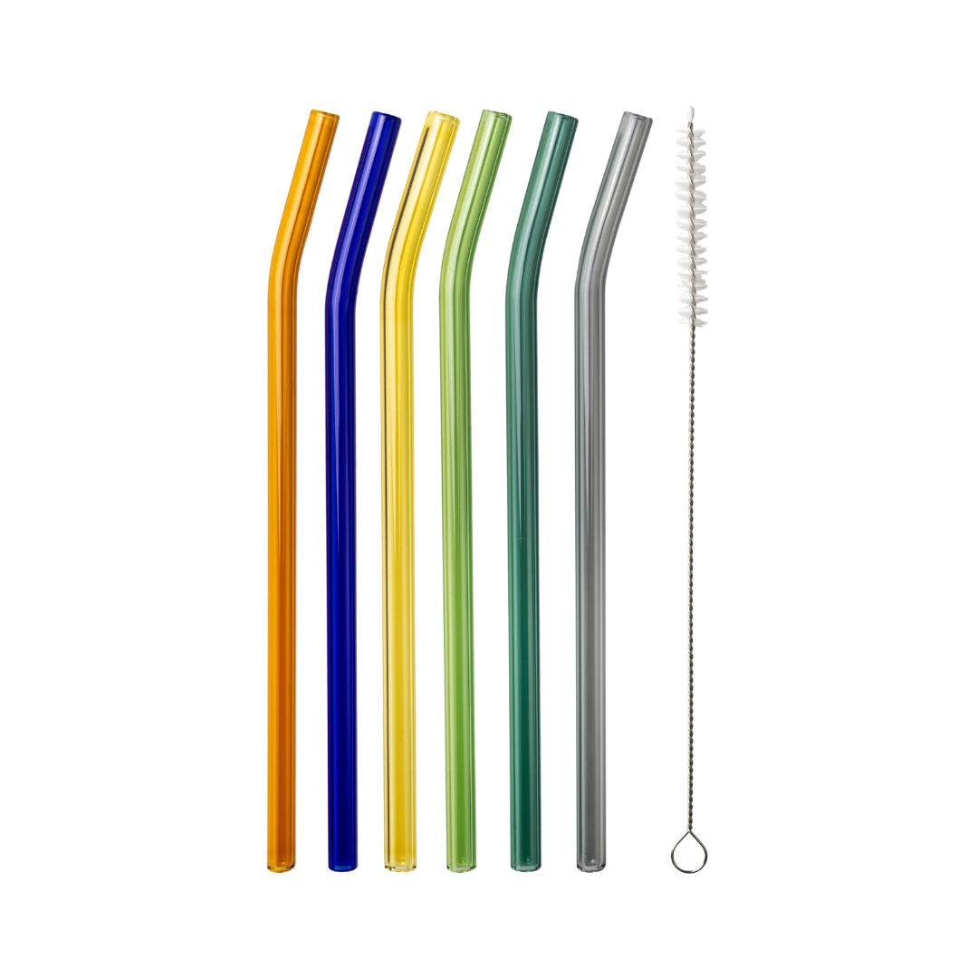 Six curved, multicolored glass straws in orange, blue, yellow, green, teal, and grey with a cleaning brush, flat lay on a light grey background.