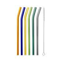 Six curved, multicolored glass straws in orange, blue, yellow, green, teal, and grey with a cleaning brush, flat lay on a light grey background.