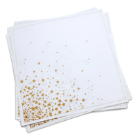 Stack of white organic cotton dinner napkins with a gold star print, by Five Star Napkins.