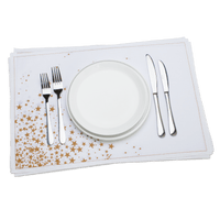 White cotton placemat with gold stars set with plate, forks, and knives, luxury table decor