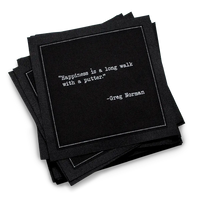 Organic cotton cocktail napkin, black, with white dotted border printed with the Greg Norman quote "Happiness is a long walk with a putter," from Five Star Napkins' Golf Legends quote collection